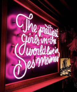 pink neon sign reads "the prettiest girls in the world live in Des Moines"